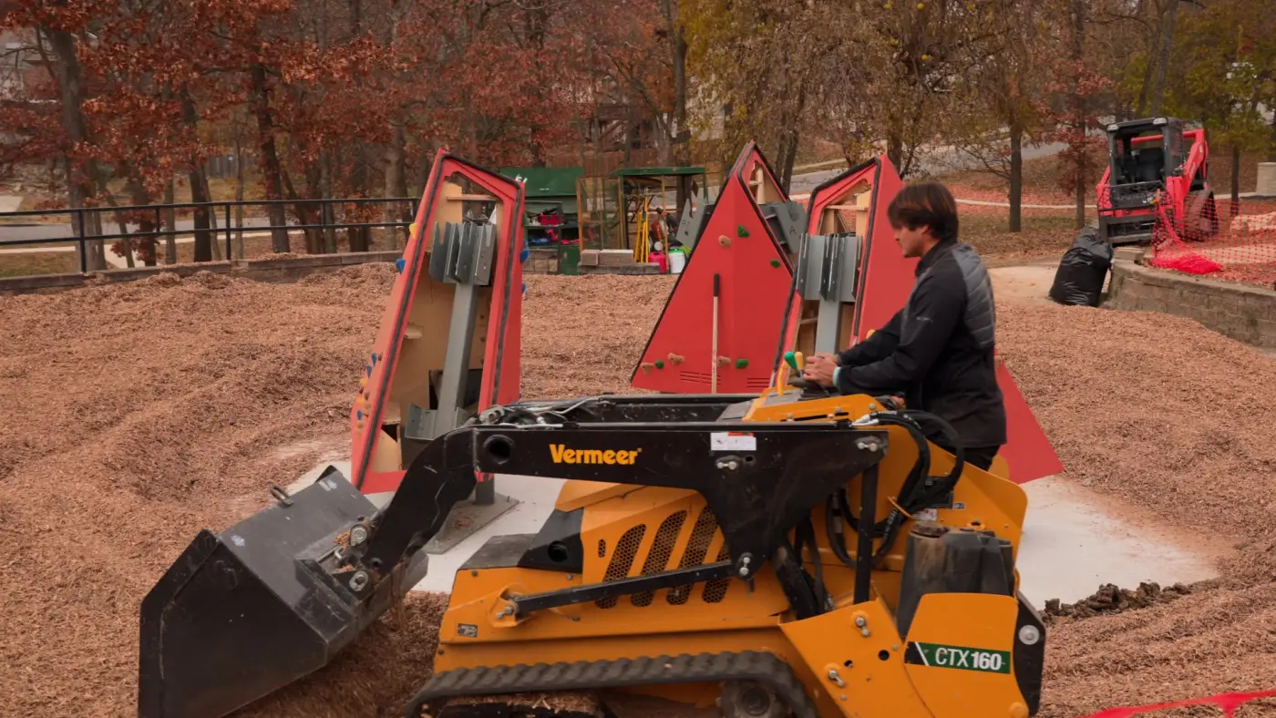 Compact loader moving surfacing on a playground site